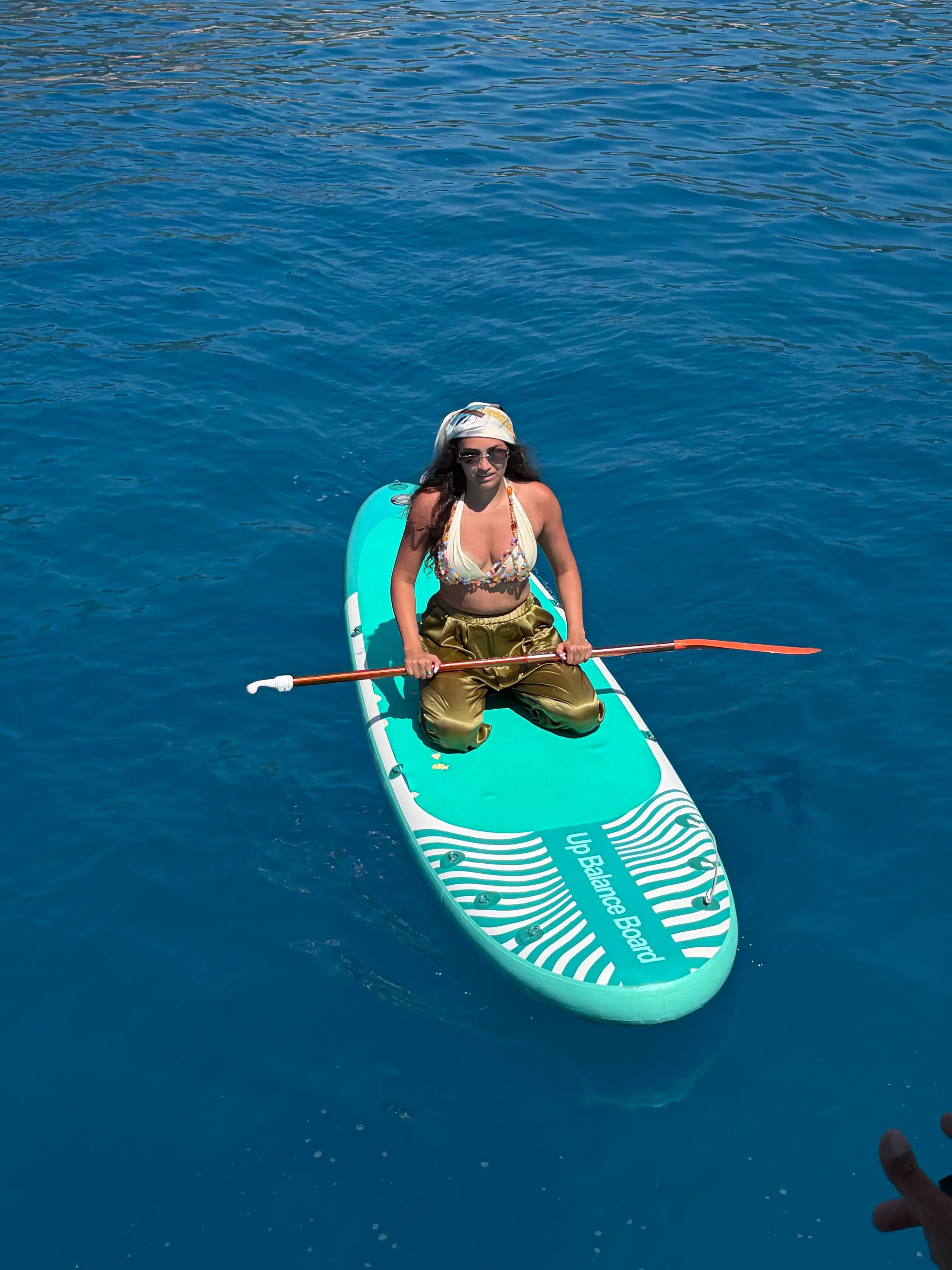 Девушка на SUP-доске на синей воде